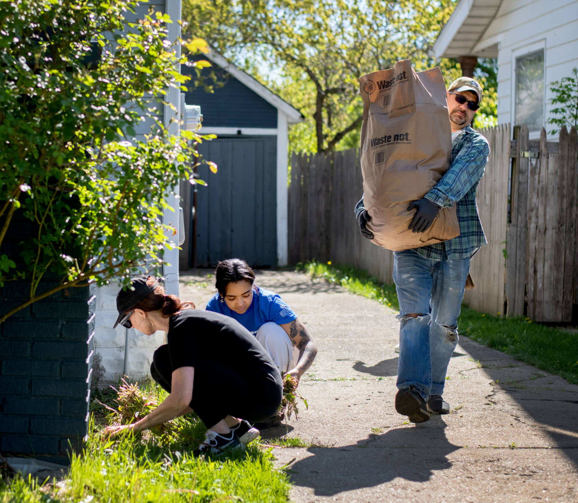 Melissa Baker-Boosamra, associate director of Office of Student Life, left, student volunteer Alex-Mari Ford, center, and Scott Hall-Jones, affiliate professor of movement science, volunteer with Operation United Way May 10.